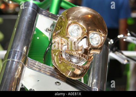 Gold coloured metallic skull with eyes as headlights on a special show motorcycle. Stock Photo