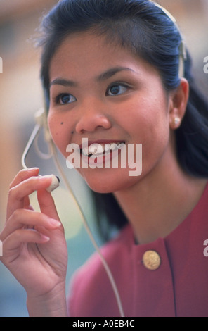 Asian woman using telephone heaset Stock Photo