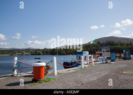 Red bollard on pier with moored boats in harbour on Kenmare River Kenmare Co Kerry Eire Stock Photo