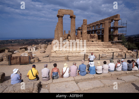 Group of tourists at the Temple of Juno (also called Hera, Lacinia) listening to guide at Agrigento, Valley of the Temples, Sicily, Italy Stock Photo