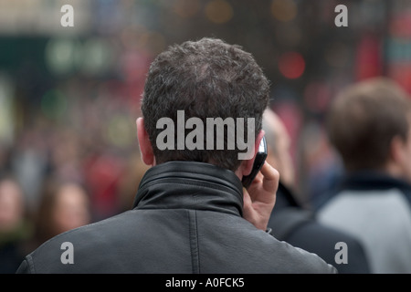 Man uses mobile phone on Oxford Street, London Stock Photo
