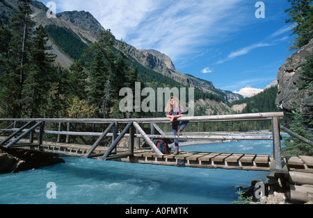 woman standing on a wooden bridge over river, Canada, Alberta, Banff NP Stock Photo