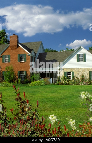 Stone and brick early American home in country setting with large yard and flower garden, Missouri USA Stock Photo