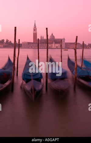 Gondolas moored beside the Canale di San Marco, Venice, Italy.  View to the Chiesa di San Giorgio Maggiore at dawn. Stock Photo