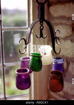 multi coloured tea lights hanging in windowsill Stock Photo