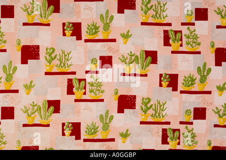 Mad 60s fabric depicting cacti and succulents in yellow plant pots on a background of red grey and pink geometric shapes Stock Photo