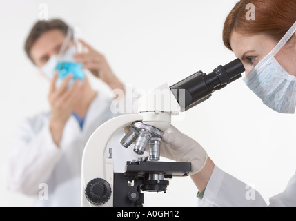 Scientists in laboratory with microscope Stock Photo