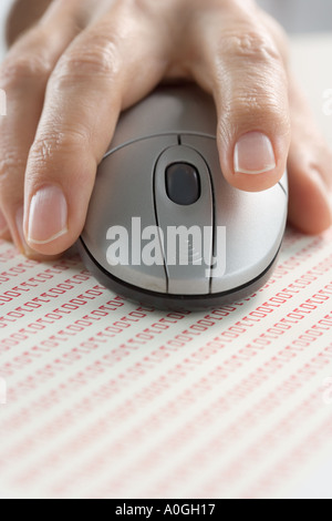 Hand on mouse with binary code Stock Photo