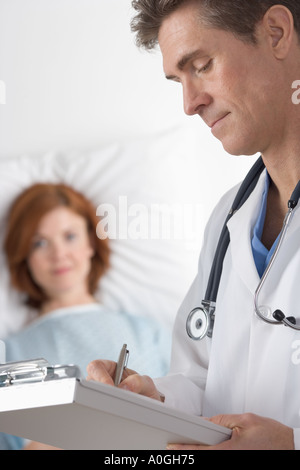 Doctor taking notes with patient Stock Photo