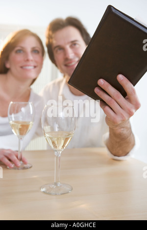 Couple with wine paying their bill Stock Photo