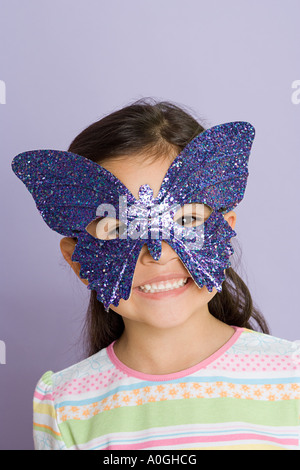 Girl wearing a butterfly eye mask Stock Photo