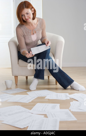 Redheaded woman sorting papers on floor Stock Photo