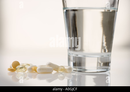 Pile of pills with water glass Stock Photo