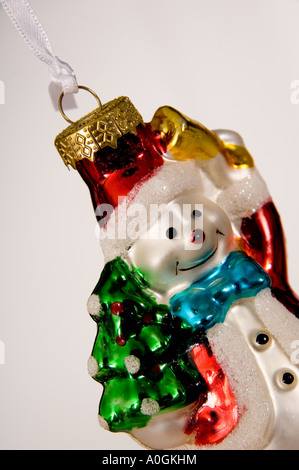 Close-up smiling snowman hanging Christmas decoration. Holding a bell and tree. Bought in Krakow Christmas Market, Poland. Stock Photo