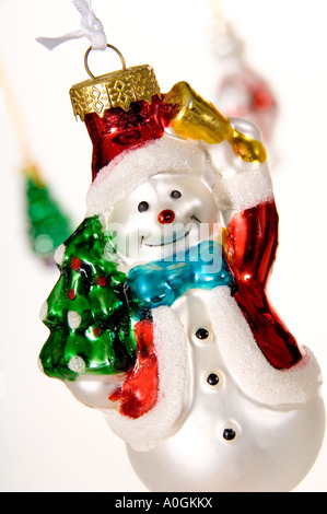 Close-up smiling snowman hanging Christmas decoration. Holding a bell and tree. Bought in Krakow Christmas Market, Poland. Stock Photo