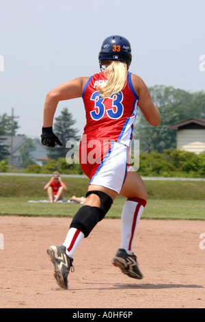 Teenage girl playing in a major league Softball game Stock Photo