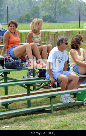 Fans at a teenage female Major league Softball game siting in the stands. Stock Photo