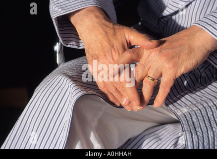 Elderly man sitting alone in a wheelchair. Disabled nursing home patient in a bathrobe. Stock Photo