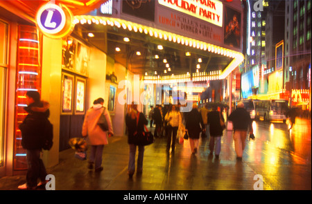 New York City street rainy night. Theatre (Theater) District Neon lights Broadway and Times Square, Midtown Manhattan. People walking on wet streets Stock Photo