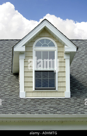 Attic Window on top of the roof of a house Stock Photo