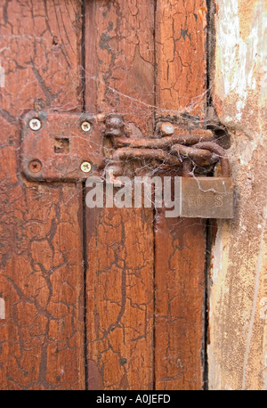 Time Lock. Rusted lock and clasp covered in cobwebs, sadly neglected Stock Photo