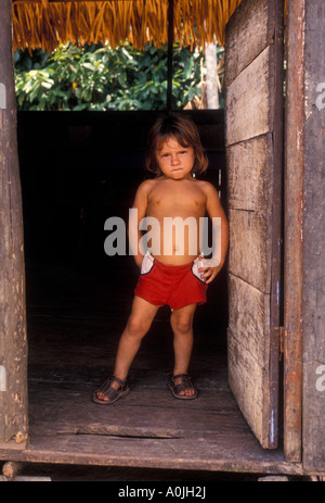 1 one Brazilian boy standing in doorway of home in family settlement along Ariau River west of Manaus, Amazonas State, Brazil, South America Stock Photo