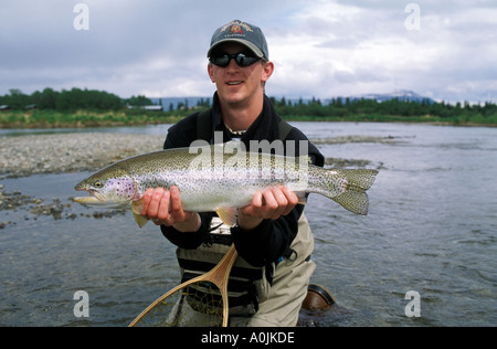 SOUTHEAST ALASKA Katmai National Park Brooks Lodge Fisherman Releasing Trophy Rainbow Trout in the Brooks River Stock Photo