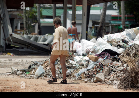 Tourists in Koh Phi Phi Southern Thailand walk past piles of debris caused by the Tsunami in 2004 Stock Photo