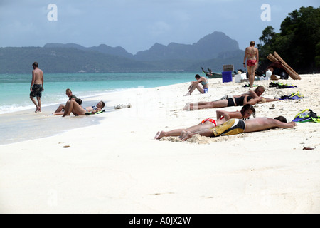 Tourist boats from Phuket and Ao Nang enable sunbathers to enjoy one of the other islands near Koh Phi Phi in Southern Thailand People sunbathe on the white sands 13 10 13 10 Stock Photo