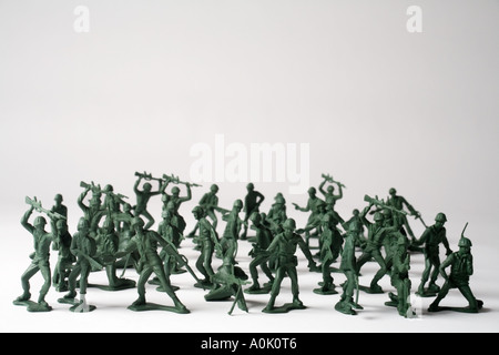 close up colour image off lots off green toy soldiers standing upright on a white surface side view, Stock Photo