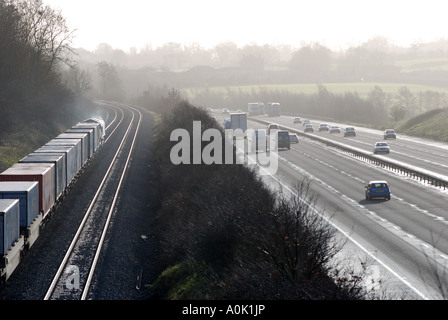 Freightliner train running parallel to M40 motorway, Rowington, Warwickshire, England, UK Stock Photo