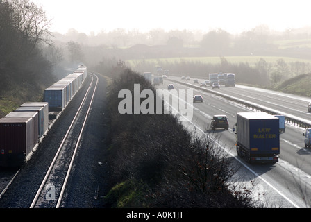 Freightliner train running parallel to M40 motorway, Rowington, Warwickshire, England, UK Stock Photo