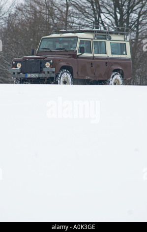 Restored 1984 Land Rover One Ten Station Wagon Diesel in original russet brown / limestone paint sheme on snowy winter journey. Stock Photo