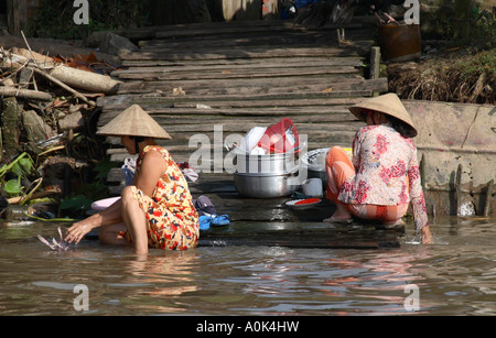 Women washing laundry and dishes in the Mekong Delta, Vietnam Stock Photo