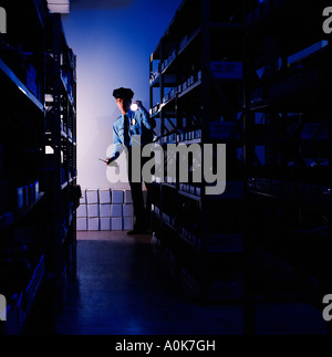 Security guard checks a warehouse at night Stock Photo