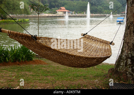 hammock hanging from tree besides a recreational  lake at Taman Titiwangsa, Kuala Lumpur, Malaysia Stock Photo