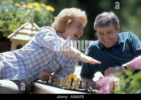 Caucasian senior couple playing chess game on deck Stock Photo