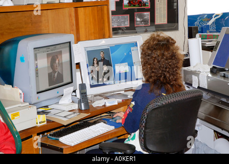 Female in a home office works with graphic arts on her computer using two monitors to aid with problems of workflow Stock Photo