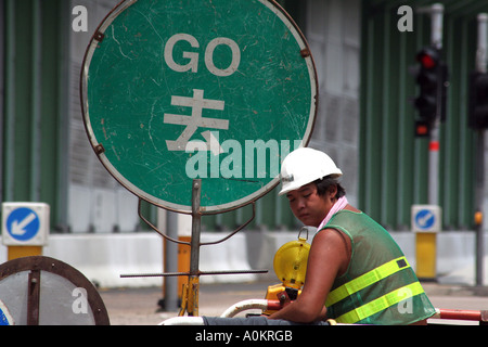 Construction worker controls traffic flow, Hong Kong Stock Photo