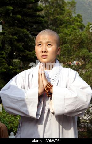 Young worshiping nun ascending ward Tian Tan Buddha, Lantau Island, Hong Kong Stock Photo