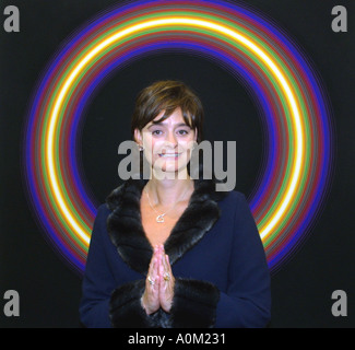 Cherie Blair, with her hands together in a mock praying gesture, standing in front of a halo like work of art Stock Photo