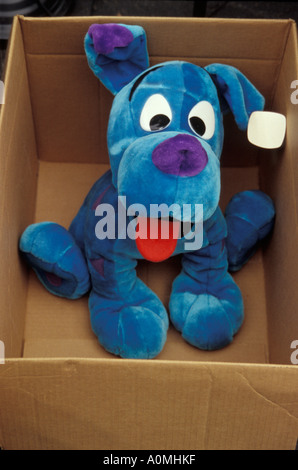 big blue stuffed toy dog in cardboard box sale tag on ear garage sale flea market copy space Stock Photo