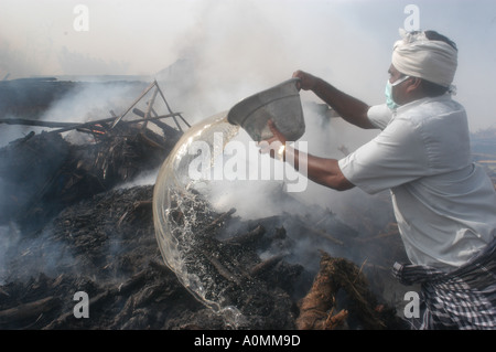 man pouring oil on funeral pyre after Tsunami earthquake Nagapattinum Velankanni Tamil Nadu India Stock Photo