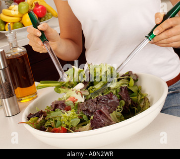 WOMAN IN KITCHEN MAKING SALAD Stock Photo