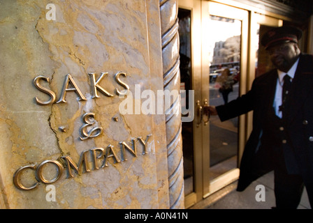 Valet holding door for aproaching woman Saks department store Uptown Manhattan New York USA Stock Photo