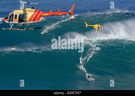 A helicopter filming a tow in surfer at Peahi, (Jaws) off Maui, Hawaii. Stock Photo
