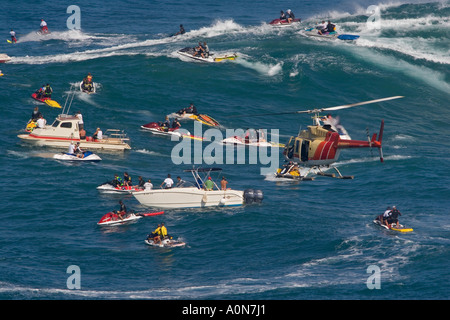 A helicopter filming a tow in surfer at Peahi, (Jaws) off Maui, Hawaii. Stock Photo