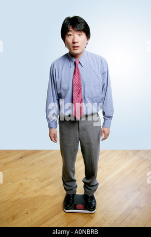 Man weighs himself on scale and is content with his weight. Stock Photo