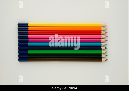 A row of ten different coloured crayons on a white background Stock Photo