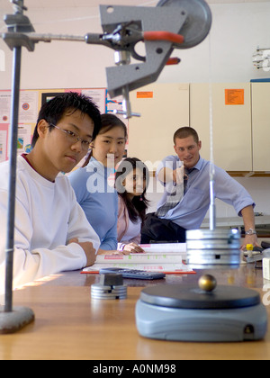 SCIENCE CLASS Students and teacher in physics classroom with gravity experiment in progress Stock Photo